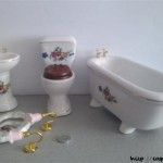 foto de todas las piezas del baño (incluidas las lámparas) que me han regalado para mi casa de muñecas. Se muestra una peseta para apreciar la escala
