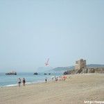 Playa con una torre árabe y el peñón de Gibraltar al fondo